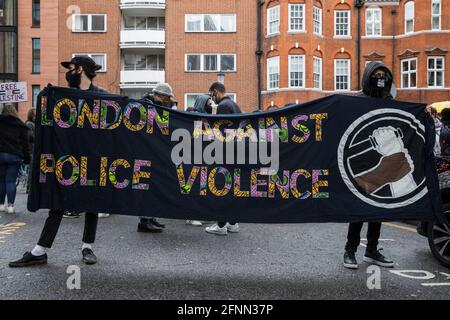 London, Großbritannien. Mai 2021. Aktivisten stehen hinter einem Transparent gegen die Gewalt der Polizei in London, während Hunderte von Menschen an einer Solidaritätskundgebung vor der kolumbianischen Botschaft von Free Palestine SOS Colombia teilnehmen. Die Redner der Veranstaltung hoben Menschenrechtsverletzungen wie die Vertreibung von Palästinensern in Israel und den besetzten Gebieten sowie die Tötung, Unterdrückung, Inhaftierung und Folter friedlicher Demonstranten und Menschenrechtsverteidiger in Kolumbien hervor. Kredit: Mark Kerrison/Alamy Live Nachrichten Stockfoto