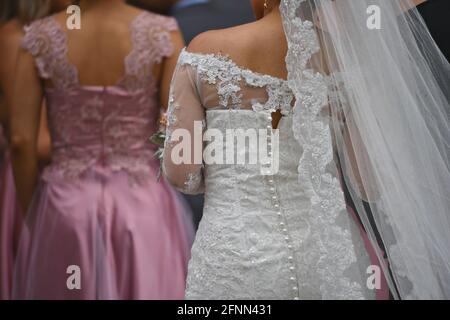 Die junge Braut trägt ein Hochzeitskleid mit Vintage-Spitze, Perlmutt-Knöpfen und transparentem Schleier in San Miguel de Allende, Guanajuato, Mexiko. Stockfoto