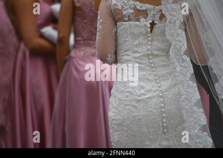 Die junge Braut trägt ein Hochzeitskleid mit Vintage-Spitze, Perlmutt-Knöpfen und transparentem Schleier in San Miguel de Allende, Guanajuato, Mexiko. Stockfoto