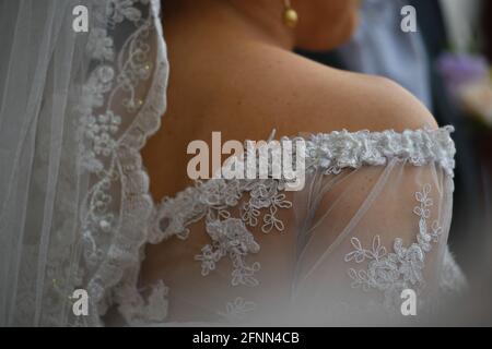 Die junge Braut trägt ein Hochzeitskleid mit Vintage-Spitze, Perlmutt-Knöpfen und transparentem Schleier in San Miguel de Allende, Guanajuato, Mexiko. Stockfoto