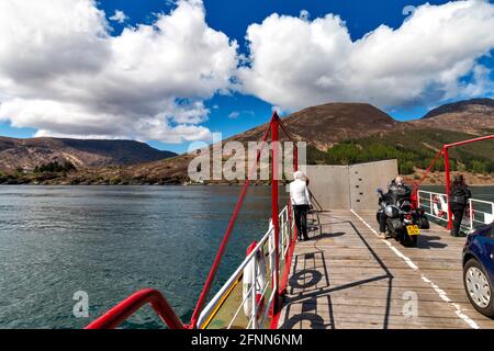 DIE FÄHRE VON GLENELG NACH SKYE ÜBER DIE KYLE RHEA STRASSE FÜHRT ÜBER DIE GLÉNACULIS PASSAGIERE AUF DEM DREHTELLER-DECK MIT BLICK AUF SKYE Stockfoto