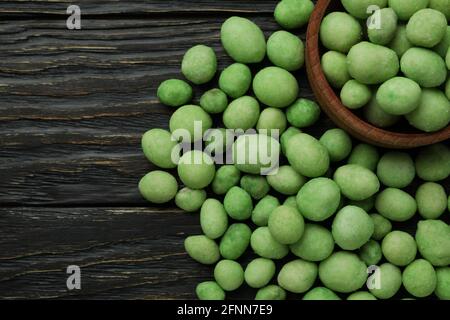 Schüssel mit Wasabi-Nüssen auf rustikalem Holzhintergrund Stockfoto