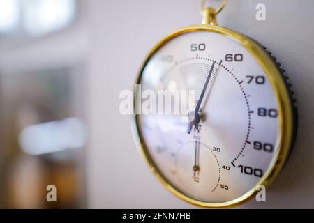 Details zur geringen Schärfentiefe (selektiver Fokus) mit einem analogen Hygrometer an der Wand eines Museums. Stockfoto