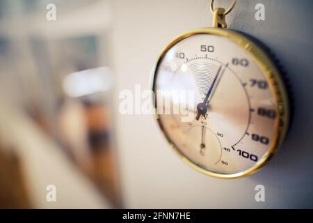 Details zur geringen Schärfentiefe (selektiver Fokus) mit einem analogen Hygrometer an der Wand eines Museums. Stockfoto