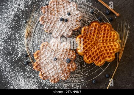 Frisch gebackene Waffeln auf einem Kühlregal auf einem dunklen Tisch Hintergrund Stockfoto