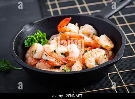 Gebratene Garnelen. Geröstete Garnelen in einer Pfanne mit Zitrone, Petersilie und Knoblauch. Stockfoto