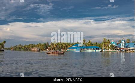 Blaue Kirche am Rande des alleppey Backwater mit Hausbooten Pfad und Palmen geben das echte Gefühl der Natur mit Gott. Stockfoto