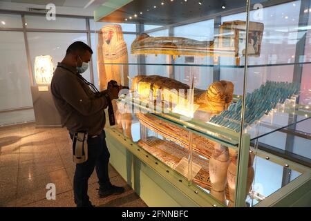 Kairo, Ägypten. Mai 2021. Ein Mann fotografiert eine Ausstellung in einem neu eröffneten Museum am internationalen Flughafen von Kairo in Kairo, Ägypten, 18. Mai 2021. Ägyptens Tourismus und Antiquitäten weihten am Dienstag zwei neue Museen am internationalen Flughafen Kairo ein, um den Internationalen Museumstag zu feiern, der jedes Jahr auf den 18. Mai fällt. Die neuen Museen, die sich in den Gebäuden des Terminals 2 und des Terminals 3 befinden, werden den Besuchern einen Blick auf die Schätze Ägyptens ermöglichen. Quelle: Ahmed Gomaa/Xinhua/Alamy Live News Stockfoto