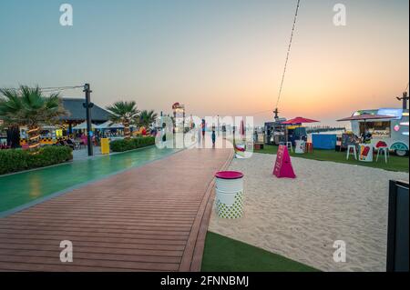 Dubai, Vereinigte Arabische Emirate, 24. März 2021: Kite-Strand in Dubai mit großer Laufstrecke, Cafés und Restaurants am Meer bei Sonnenuntergang auf einem Stockfoto