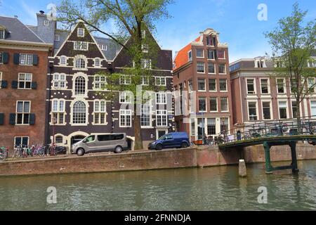 AMSTERDAM, NIEDERLANDE - 10. JULI 2017: Besucher besuchen den Oudezijs Voorburgwal Kanal in Amsterdam, Niederlande. Der Canal Ring aus dem 17. Jahrhundert liegt in der Nähe der Stadt Stockfoto