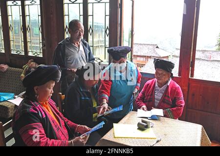 Nanning, China. Mai 2021. (210518) -- NANNING, 18. Mai 2021 (Xinhua) -- Pan Jiping (2., R) stellt Wissen zur Pandemievorsorge im Dorf Xiaozhai der Gemeinde Longji, Bezirk Longsheng, südchinesische Autonome Region Guangxi Zhuang, 18. Mai 2021 vor. In Xiaozhai, einem Dorf am Fuße des Berges Fupingbao auf über 1,900 Metern Höhe, ist Pan Jiping seit mehr als 30 Jahren Landarzt hier. Pan, 57, gehört zu den Menschen in Hongyao, einem Zweig der Yao-Volksgruppe. Stockfoto