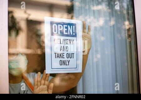 NUR HERAUSNEHMEN! Bitte beachten Sie die soziale Distanzierung bei der Bestellung von Zeichen in einem Fenster während COVID-19. Stockfoto