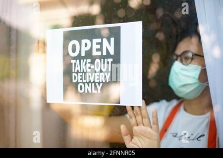 NUR HERAUSNEHMEN! Bitte beachten Sie die soziale Distanzierung bei der Bestellung von Zeichen in einem Fenster während COVID-19. Stockfoto