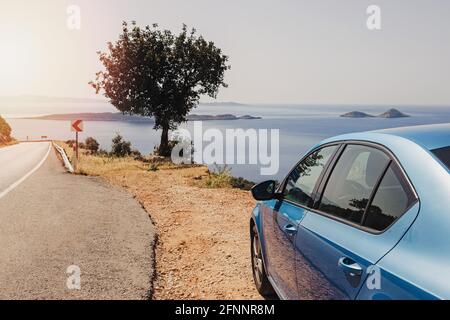 Blaues Auto hielt am Straßenrand in der Nähe des Meeres an sonnigen Tag Stockfoto