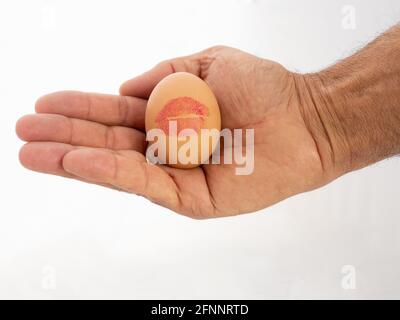 Nahaufnahme eines Eies mit einem Kuss-Aufdruck Die Hand einer Person Stockfoto