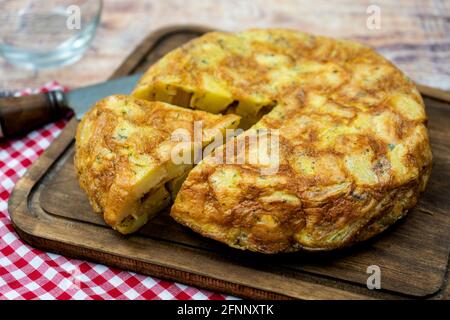 Typisch spanisches Omelett von Kartoffeln oder Kartoffeln mit einer Portion in einer rustikalen Umgebung geschnitten. Spanische Küche. Stockfoto