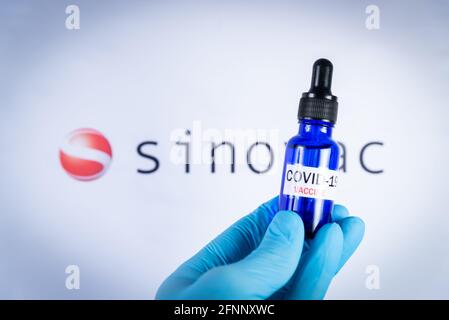 Am 18. Mai 2021 hält eine Hand eine Flasche vor dem Sinovac-Impfstofflogo in Barcelona, Spanien. Sinovac Biotech Ltd ist ein chinesisches Pharmaunternehmen pro Stockfoto