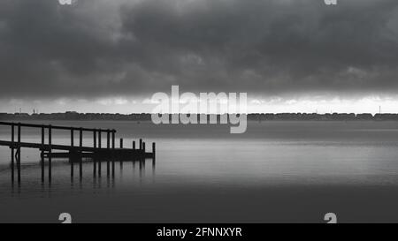 Anlegestelle am Christchurch Harbour an EINEM stürmischen Tag mit Mudefrod Spit and Beach Huts in the Distance UK Monochrom Stockfoto