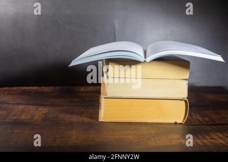 Das offene Buch auf EINEM Stapel Bücher Stockfoto