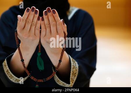 Nahaufnahme einer muslimischen Frau Hände in Abaya, während sie den Rosenkranz mit ihren Händen hält und betet. Religion beten Konzept. Vereinigte Arabische Emirate Stockfoto