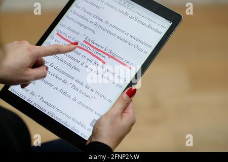 Frau liest und studiert die Evangelien der bibel auf einem digitalen iPad. Frankreich. Stockfoto