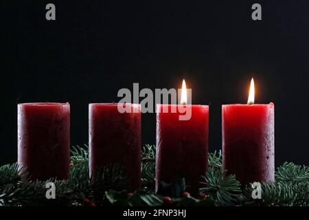 Natürlicher Adventskranz oder Krone mit zwei brennenden roten Kerzen. Weihnachtskomposition. Frankreich. Stockfoto