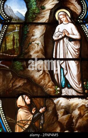 Basilika Notre Dame de l’Assomption. Buntglasfenster. Unsere Dame von Lourdes und Bernadette Soubirous. Schön. Frankreich. Stockfoto