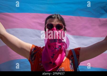 Während des Protestes wird ein Aktivist mit einer Gesichtsmask gesehen, der die Trans-Flaggen hält. Aktivisten der Trans Community protestieren vor dem Abgeordnetenkongress. Die Abstimmung über die Bearbeitung des "transstaatlichen Gesetzes" wird am Dienstag, dem 18. Mai, in der Plenarsitzung des spanischen Kongresses diskutiert. (Foto von Guillermo Gutierrez / SOPA Image/Sipa USA) Stockfoto