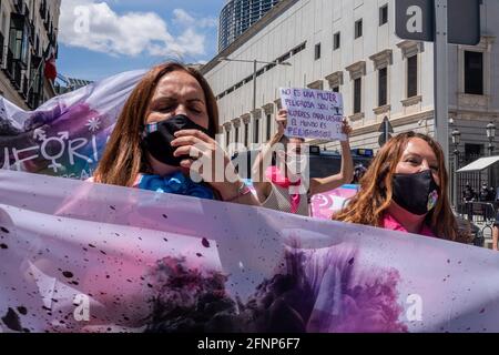 Demonstranten, die Gesichtsmasken tragen, halten während des Protestes Flaggen fest und singen Slogans. Aktivisten der Trans Community protestieren vor dem Abgeordnetenkongress. Die Abstimmung über die Bearbeitung des "transstaatlichen Gesetzes" wird am Dienstag, dem 18. Mai, in der Plenarsitzung des spanischen Kongresses diskutiert. Stockfoto