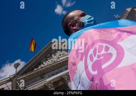 Während des Protestes wird ein Aktivist mit einer Gesichtsmask gesehen, der die Trans-Flaggen hält. Aktivisten der Trans Community protestieren vor dem Abgeordnetenkongress. Die Abstimmung über die Bearbeitung des "transstaatlichen Gesetzes" wird am Dienstag, dem 18. Mai, in der Plenarsitzung des spanischen Kongresses diskutiert. Stockfoto