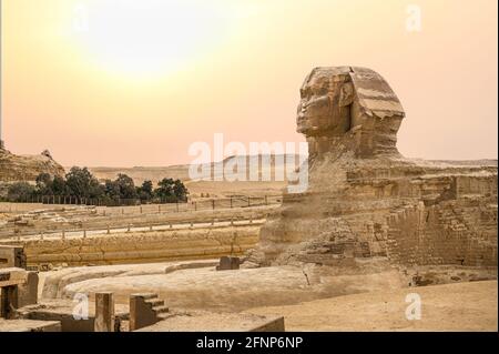Landschaft mit ägyptischen Pyramiden, großer Sphinx und Silhouetten Antike Symbole und Wahrzeichen Ägyptens für Ihr Reisekonzept nach Afrika in goldener Sonne Stockfoto