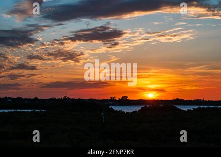 Eine Landschaftsaufnahme eines farbenfrohen Sonnenuntergangs in Florida mit roten, orangen und blauen Tönen in der Nähe von Tampa, Florida, in einem Naturschutzgebiet Stockfoto