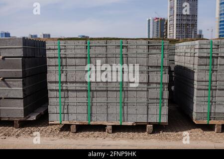 Unterflurstein auf der Baustelle. Palette mit einem Stapel Beton-Randstein. Straßenreparaturen. Stockfoto