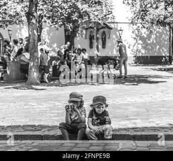 Zwei Jungen setzten sich hin und beobachteten das Straßenleben Stockfoto