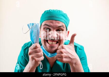 Lustiger Arzt mit einer medizinischen Maske in den Händen. Stockfoto