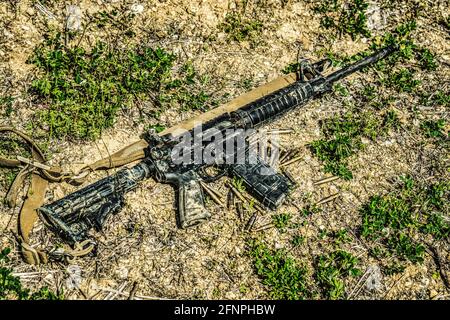 Ein moderner automatischer amerikanischer Karabiner, der auf dem Boden im Schlamm liegt. Waffen unter extremen Bedingungen. Testen von Waffen auf Stärke, Leistung und Praxis Stockfoto