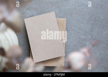Leere, braunes Kraftpapier-Briefpapier-Karte mit getrockneten Eukalyptusblättern Stockfoto