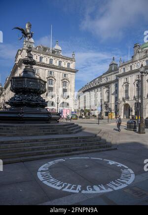 Leerer, kreisförmiger Straßenbusker-Straßenpflaster am Piccadilly Circus unter der Statue des Eros in London, Großbritannien, an einem ruhigen Morgen, dem 18. Mai 2021 Stockfoto