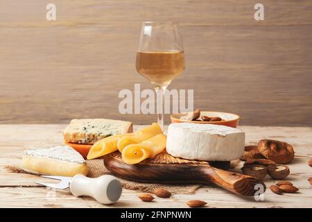 Verschiedene Arten von Käse, Wein, getrockneten Feigen und Nüssen auf Holzgrund Stockfoto