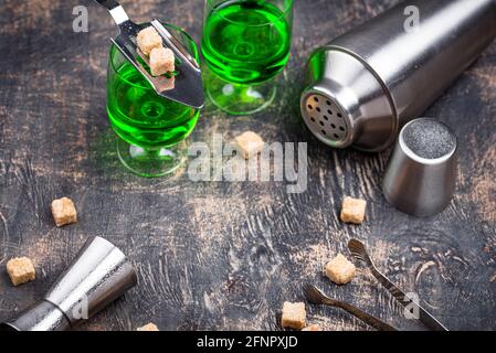 Ein Glas Absinth mit Rohrzucker Stockfoto