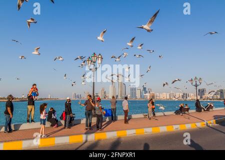 ABU DHABI, VAE - 7. MÄRZ 2017: Die Menschen beobachten die Skyline von Abu Dhabi von der Marina Breakwater aus, Vereinigte Arabische Emirate Stockfoto