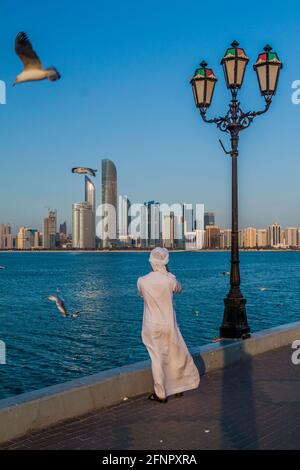 ABU DHABI, VAE - 7. MÄRZ 2017: Der Einheimische fotografiert die Skyline von Abu Dhabi von der Marina Breakwater, Vereinigte Arabische Emirate Stockfoto