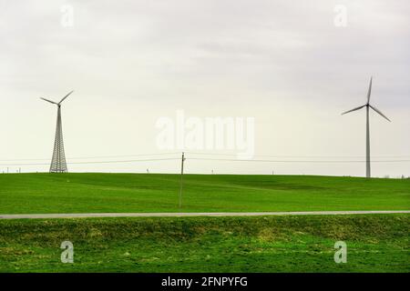 Zwei Windturbinen drehen sich um die Energieerzeugung in der Mitte eines Weizenfeldes. Windparks, werden zu einer immer wichtigeren Quelle von Stockfoto