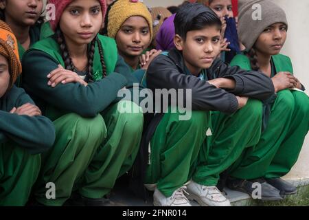 Uttar Pradesh, Indien. 05-11-2019. Eine Gruppe junger indischer weiblicher Jugendlicher schaut ernsthaft auf die Kamera, während sie ihre Outdoor-Schule besuchen Stockfoto