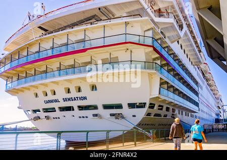 Touristen laufen am Karneval vorbei, der am GulfQuest Museum am Alabama Cruise Terminal, 14. Mai 2021, in Mobile, Alabama, angedockt ist. Stockfoto