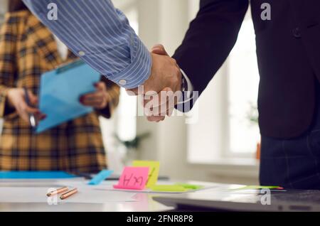 Geschäftshandschlag von zwei männlichen Geschäftsleuten nach erfolgreichem Büromeeting Stockfoto