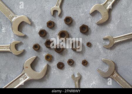 Schraubenmuttern und Schrauben auf Steinhintergrund Stockfoto