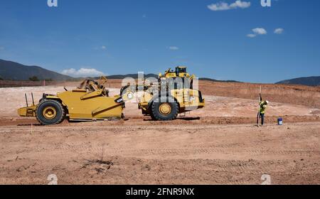 Ein Schwermaschinenfahrer verwendet einen Radtraktorschaber Caterpillar 623H, um Schmutz auf der Baustelle zur Verbesserung der Autobahn in Santa Fe, New Mexico, zu entfernen. Stockfoto