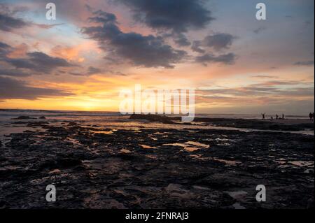 Farbenprächtiger Sonnenuntergang über dem Strand mit Pools in Felsen Costa Rica Stockfoto