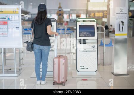 BANGKOK THAILAND APR 14 2021 weibliche Hand, die den Check-in mit Selbstbedienung nutzt, um die Bordkarte am Flughafen zu erhalten. Stockfoto